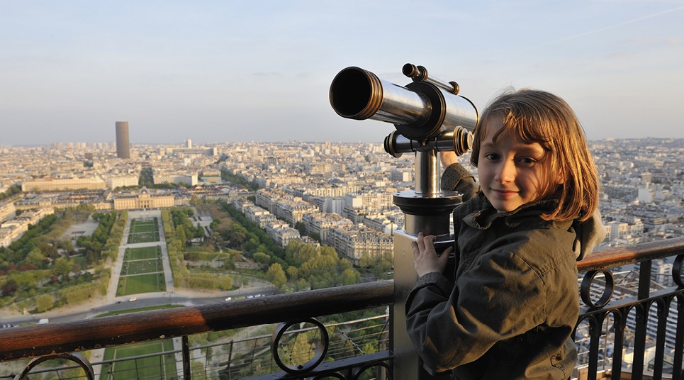 Criança admira Paris do alto
