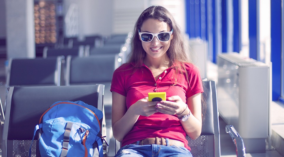 Viajante usando celular em aeroporto